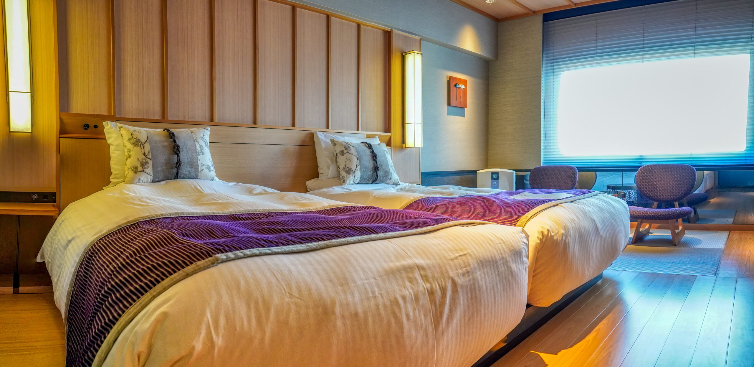 Bright Japanese hotel bedroom with a wide bed and wood-panelled interior in Kyoto
