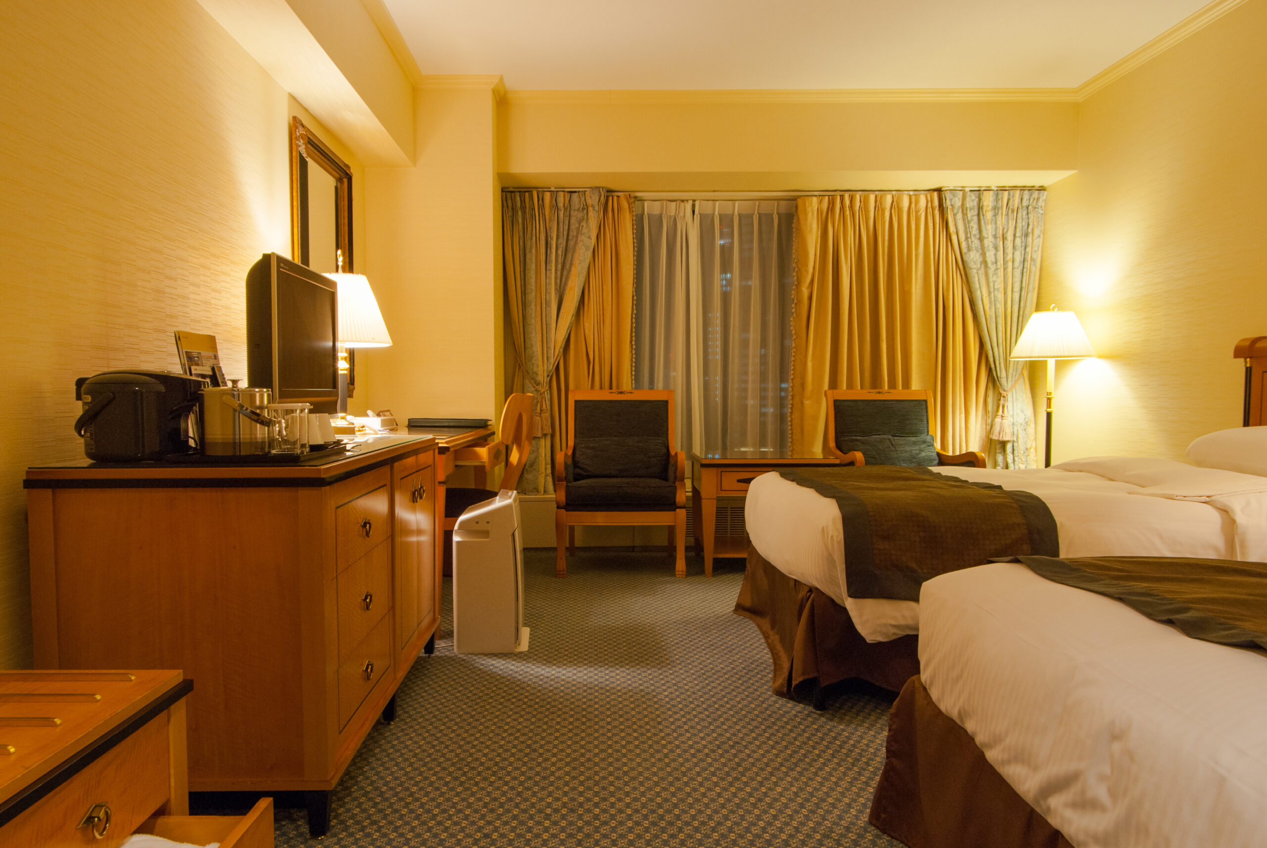 Spacious twin hotel room in Osaka with seating and luggage space